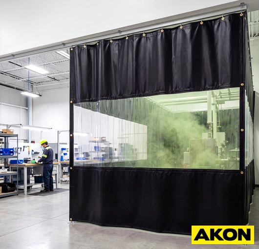 Industrial fume and odor control curtains installed in a facility to contain airborne contaminants within a work zone.