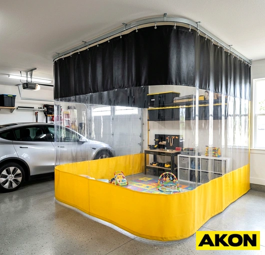 Heavy-duty curtains enclosing a garage opening to separate interior work space from the outside.