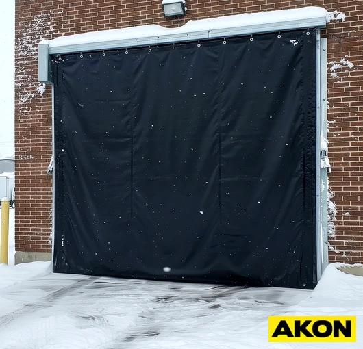 Heavy-duty industrial curtains installed in a large commercial or manufacturing facility to divide workspace areas.