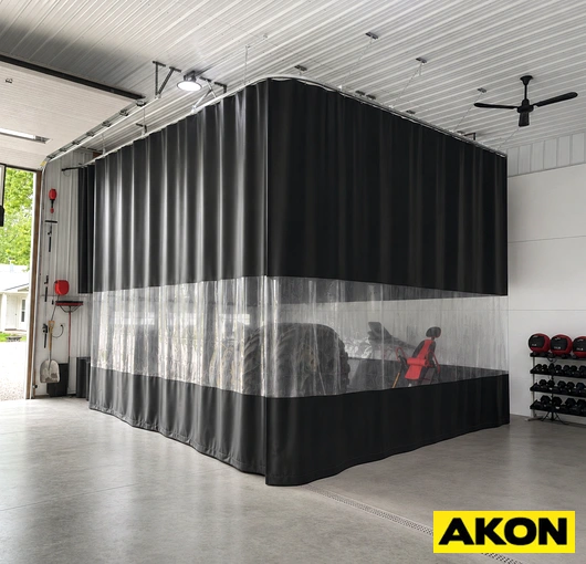 Heavy duty industrial curtains hanging in a large warehouse or manufacturing facility to divide work areas.