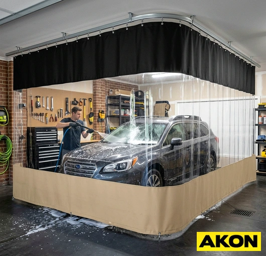 Heavy-duty vinyl curtains installed in a commercial garage wash bay to contain water spray and separate work areas.