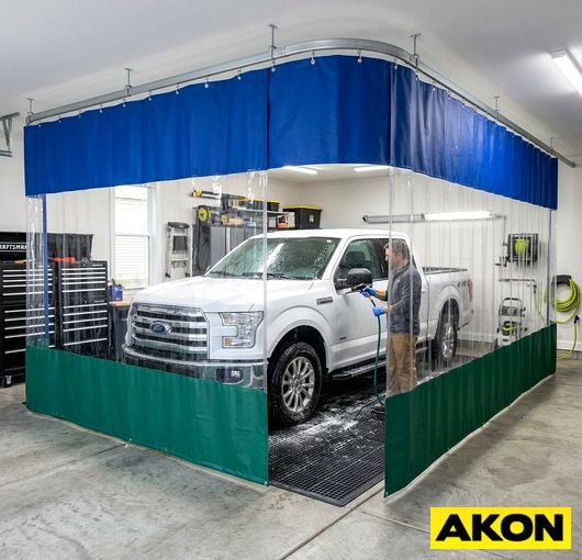 Heavy-duty curtains installed in a commercial garage wash bay to contain water, spray, and debris during vehicle washing.