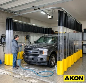 Heavy-duty vinyl curtains installed in a commercial garage wash bay to contain water and spray during vehicle washing.