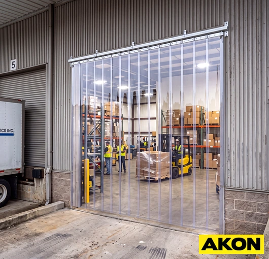 Heavy-duty curtains installed at a loading dock doorway to control temperature and separate interior and exterior environments.
