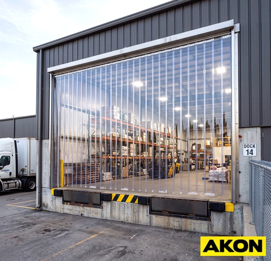 Plastic door curtains hanging in an industrial doorway, forming a flexible barrier between work areas.