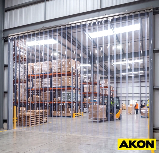 Heavy duty vinyl strip curtains hanging in an industrial doorway to separate work areas and control temperature.