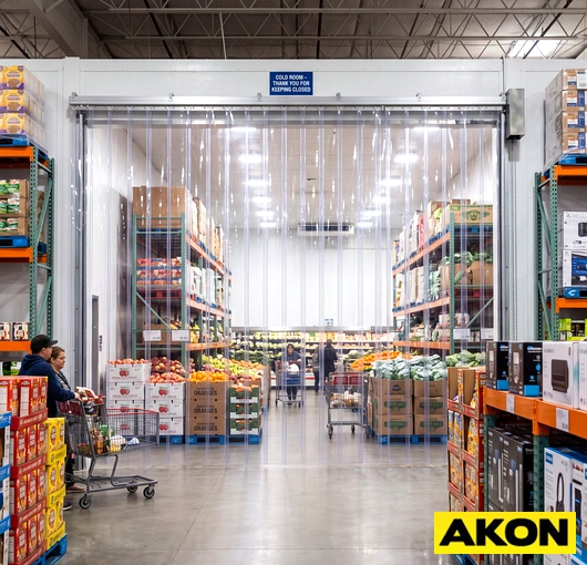 Industrial PVC strip curtain hanging in a warehouse doorway to separate work areas and control temperature.