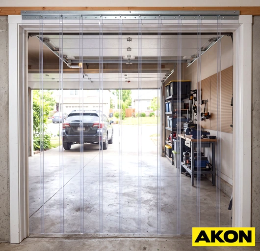 PVC vinyl strip curtains hanging in an industrial doorway to separate work areas and control temperature.