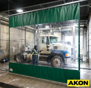 Heavy-duty commercial curtains installed in an industrial wash bay to contain water spray and separate work zones.