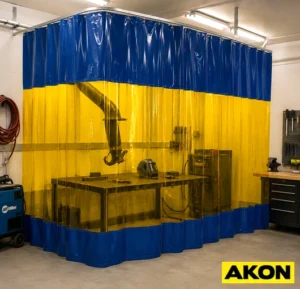 A welding curtain hanging in an industrial workspace to contain sparks and shield nearby workers from arc flash.