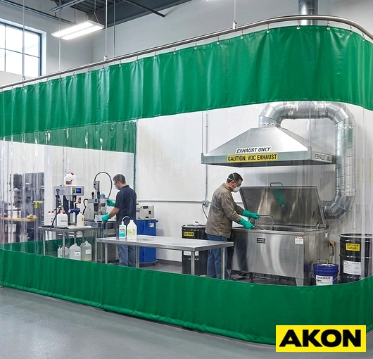 Heavy-duty isolation curtains hung in an industrial facility to separate work zones and control airborne contaminants.