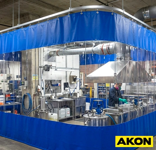 A weatherproof isolation curtain installed in an industrial facility to block weather, drafts, and contaminants at a large opening.
