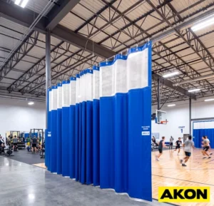 Heavy-duty reusable partition curtains dividing a gym space into separate activity areas.