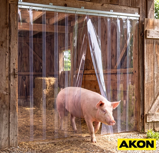 PVC strip curtain installed at a pig barn doorway to control airflow and separate livestock areas.