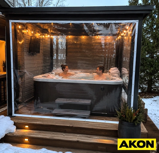 Clear vinyl tarp enclosing a hot tub on an outdoor patio during winter, blocking wind and retaining heat.