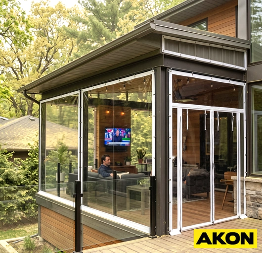 A clear patio curtain with a pollen screen attachment installed on an outdoor patio enclosure.