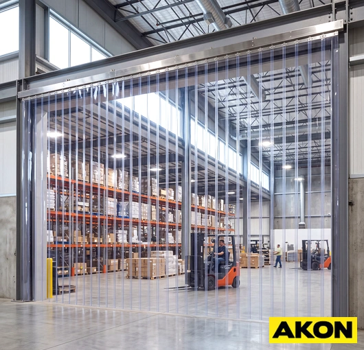 Durable PVC strip curtains hanging in an industrial doorway to separate work areas.