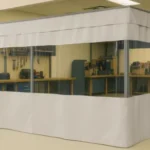 How to turn an empty retail storefront into a functional workshop using curtain partitions, featuring an all-white vinyl divider with clear panels, organized workbenches, tool storage, and shelving in a bright, repurposed industrial space
