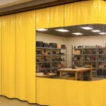 How to turn an empty retail storefront into a functional workshop using curtain partitions, featuring bright yellow industrial curtains with a clear viewing panel, organized shelving, and workbenches inside
