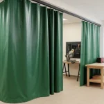 How to turn an empty retail storefront into a functional workshop using curtain partitions, featuring green industrial curtains creating a work area with tool benches and natural light from large windows