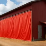 Red barn with a large industrial curtain wall for climate control in barns and animal facilities, helping regulate temperature and protect livestock inside