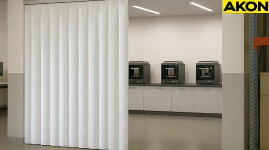 Using curtain walls to reduce airborne contaminants in 3D printing labs with white vinyl partition partially open to reveal multiple 3D printers inside