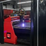 Black welding curtain plasma burn table enclosure with red cutting machine containing sparks Plasma Burn Table Enclosures Containment with Welding Curtains
