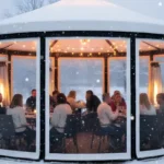 Circular winter patio enclosure with guests dining inside a heated vinyl igloo-style structure Extend Patio Season Restaurant and Café Enclosure Ideas For Winter