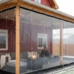 Clear vinyl pergola side panels enclosing a red house patio during snowfall – Pergola Side Panels Temporary Winter Solutions That Look Built-In