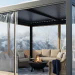Enclosed porch with Roll-up Clear Patio Curtains – Keep Your View in Winter, shielding a cozy outdoor sofa set from snow and cold