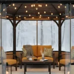 Gazebo enclosed with transparent PVC panels and amber seating, surrounded by snow Convert a Gazebo to a Cozy Winter Room with Removable PVC Panels