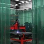 Green vinyl plasma burn table enclosure with welding curtains surrounding cutting machine Plasma Burn Table Enclosures Containment with Welding Curtains
