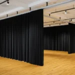 How dance studios use curtain walls for private lessons or auditions, showing black dividers creating modular rehearsal rooms within one studio