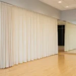 How dance studios use curtain walls for private lessons or auditions, using neutral ivory dividers to create private mirrored dance areas