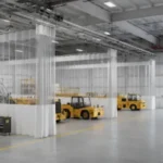 Industrial curtain walls for airport maintenance hangars and staging areas, using tall white dividers to create enclosed work sections around airplanes.