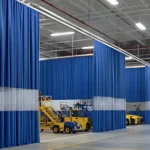 Industrial curtain walls for airport maintenance hangars and staging areas, with tall blue and white dividers creating flexible zones around aircraft