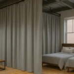 Industrial curtains for dividing large Airbnb properties or group lodges, with ash gray fabric creating private sleeping and lounge areas in shared rental spaces.