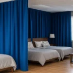 Industrial curtains for dividing large Airbnb properties or group lodges, with royal blue fabric creating private sleeping and lounge areas in shared rental spaces