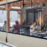 Outdoor dining patio with clear vinyl enclosures keeping guests warm in winter Extend Patio Season Restaurant and Café Enclosure Ideas For Winter