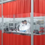 Red vinyl curtain walls enclose quality control area for inspections, ensuring privacy and maintaining a clean inspection space