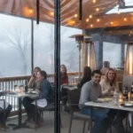 Restaurant patio enclosed with clear vinyl curtains and heaters, extending outdoor dining season Extend Patio Season Restaurant and Café Enclosure Ideas For Winter