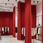Retail showroom curtains in bold red dividing high-traffic sections of a stylish clothing showroom