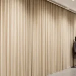 Retail showroom curtains in golden yellow dividing large display areas in a modern clothing store.