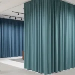 Retail showroom curtains in teal used to section off large display areas in a fashion showroom