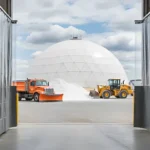 Retractable Curtain Walls for City Public Works Yards and Salt Dome Storage Areas with clear vinyl panels allowing visibility to outdoor salt dome and equipment