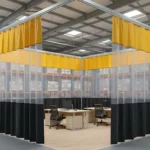 Temporary office space inside warehouses using curtain wall systems with black vinyl panels and yellow top trim combined with clear PVC sections