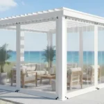 White pergola enclosure with clear vinyl panels by the ocean, showing durability against salt and wind. Pergola Enclosures for Coastal Climates Salt, Wind, and Care