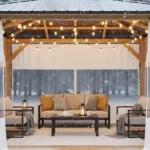 Wooden gazebo with clear PVC panels, hanging lights, and beige seating for winter use Convert a Gazebo to a Cozy Winter Room with Removable PVC Panels