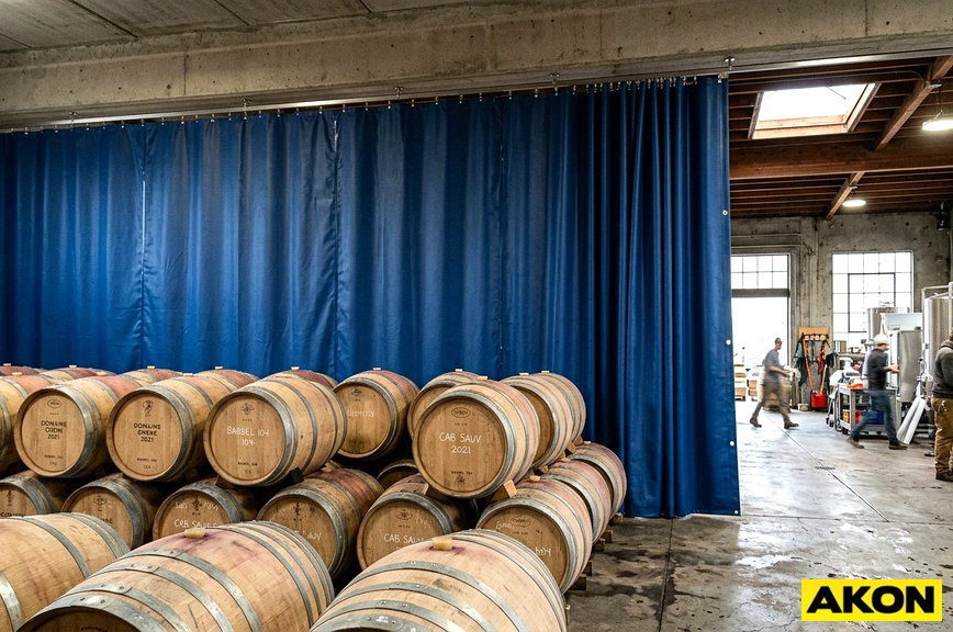 Commercial curtain wall installed in an industrial barrel room to divide and enclose the storage area.