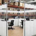 emporary office space inside warehouses using curtain wall systems made of white vinyl panels with clear PVC walls for bright, clean office areas